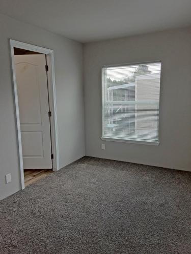 A room with a window and carpet.