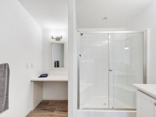 A bathroom with a glass shower and a sink.