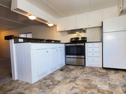 A kitchen with white cabinets and appliances.