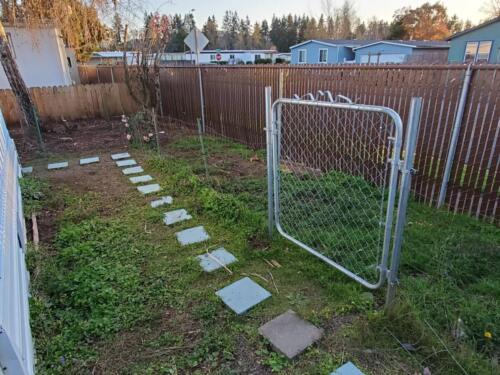 A fenced yard with a gate and a fence.